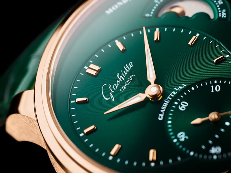 Glashütte Original PanoMaticLunar နာရီကို စိမ်းလန်းစိုပြေသော ရွှေရောင်နှင့် အနီရောင်တို့ဖြင့် ပြသထားသည်။