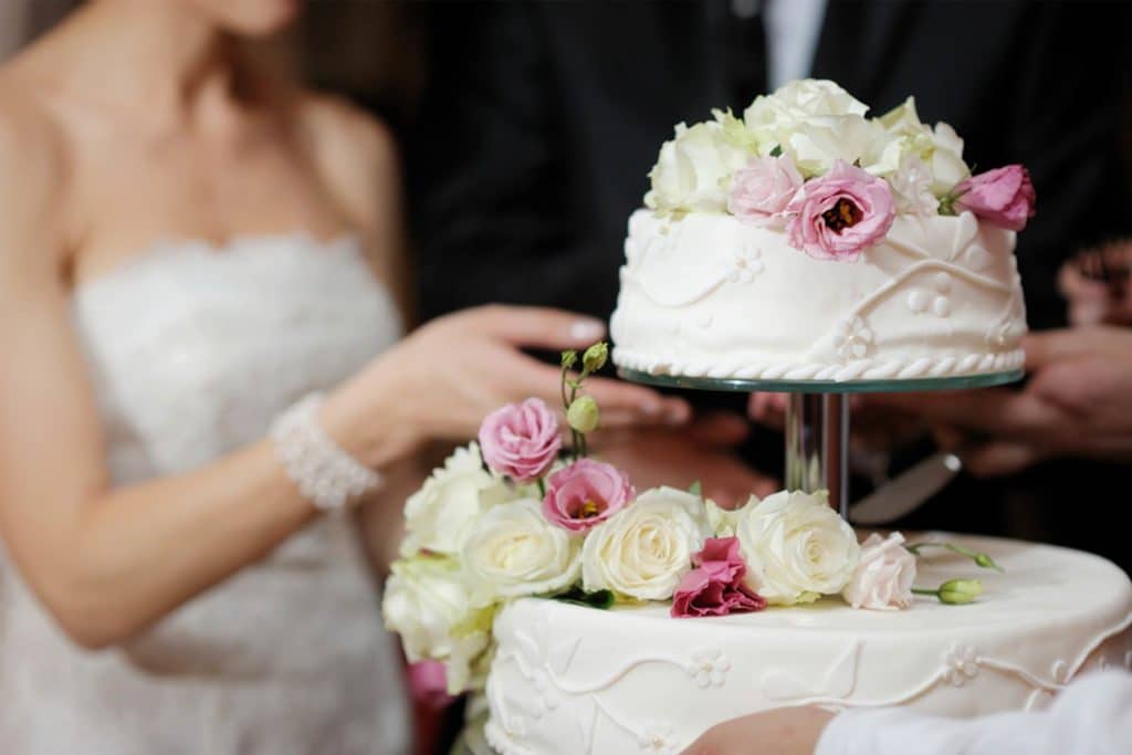 Un marié casse un gâteau de mariage selon l'opinion de sa mariée